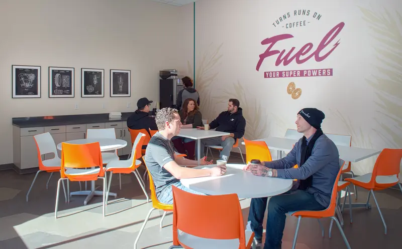 Breakroom with orange chairs and a Fuel coffee mural
